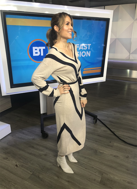 Dina wearing v-shaped long dress with white pointy boots